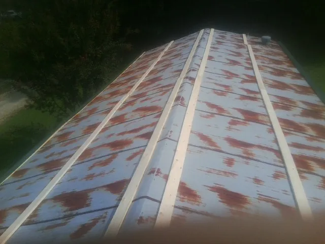 Rusted metal roof panels with new wood purlins before replacement — Storm Damage Roof Repair in Austinville by Roofing Brothers
