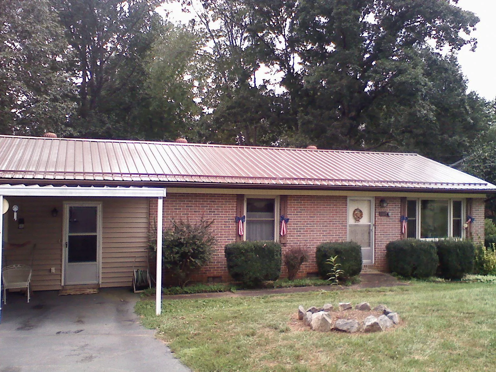 Bronze metal roof and carport on a brick ranch home — Roof Repair work by our crew in Austinville
